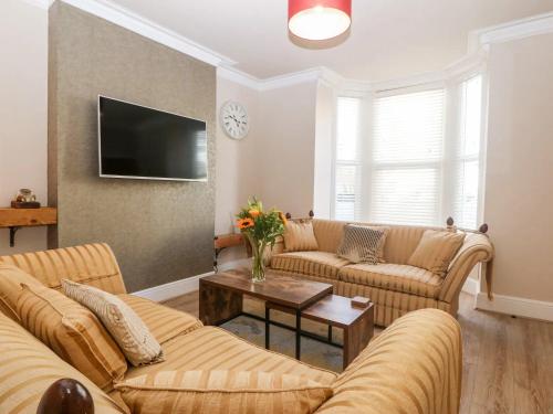 a living room with two couches and a tv at Llandudno 3 Bedroom Holiday Apartment in Town Centre in Llandudno