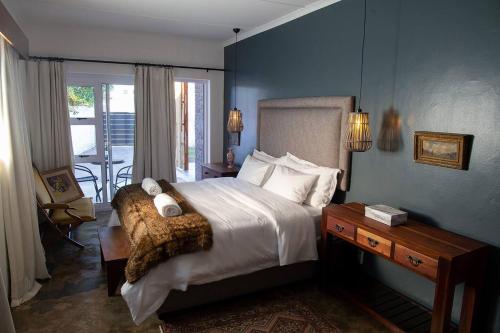 a bedroom with a large bed and a balcony at Barbethuijs in Jeffreys Bay