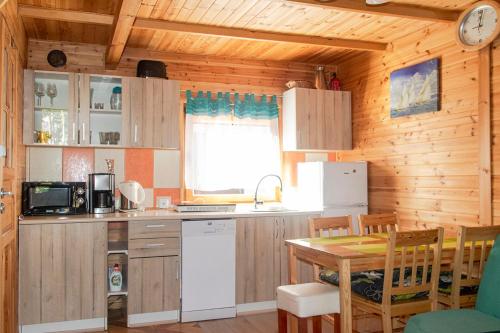 a kitchen with wooden walls and a table in a room at O.W.Sztil in Pobierowo