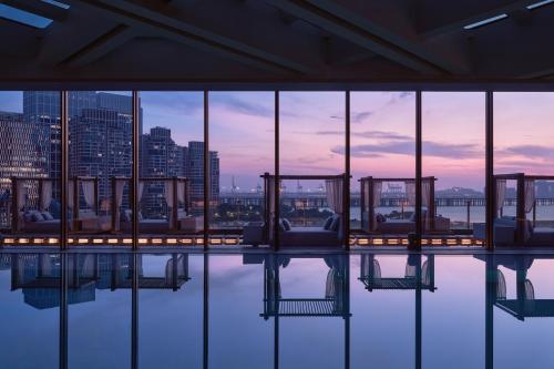 a view of the city from the top of a building at Conrad Shenzhen, the first art museum hotel in Greater Bay Area with the stunning bay and sunset view in the hotel terrace in Shenzhen
