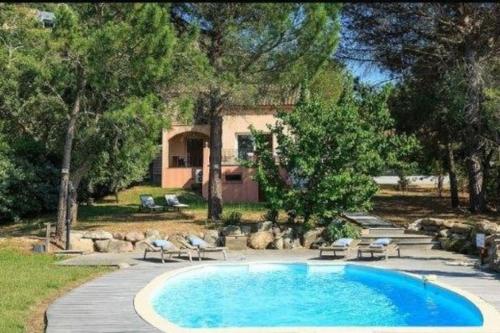 une piscine dans une cour avec des chaises et une maison dans l'établissement Villa Casetta Bianca 2 chambres, Piscine et accès mer, à Porto-Vecchio