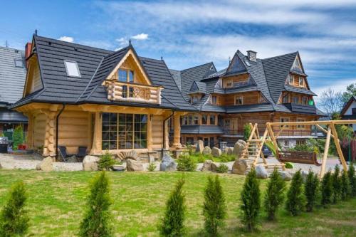 duży domek z bali z dachem gambrel w obiekcie Domek & Apartament Góralski z Jacuzzi Kościelisko w mieście Kościelisko