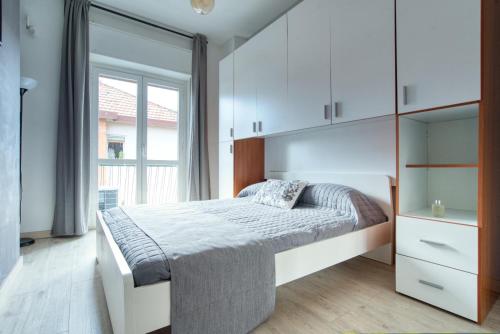 a bedroom with a bed with white cabinets and a window at Soggiornare sul Naviglio in Milan