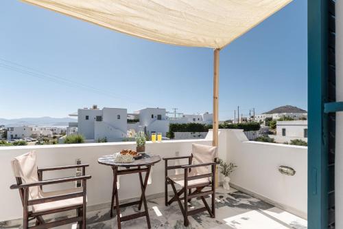 a patio with a table and chairs on a balcony at Golden Silence Studios in Agios Prokopios