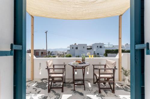 a patio with a table and chairs on a balcony at Golden Silence Studios in Agios Prokopios