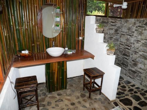 ein Badezimmer mit einem Waschbecken und zwei Hockern in der Unterkunft Paradiselodge Casa Romantica in Platanillo