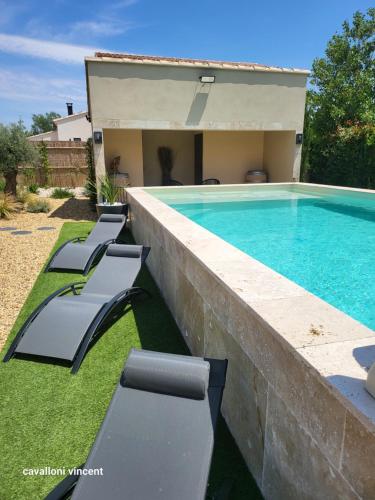 a swimming pool with lounge chairs next to a house at Villa Paradou in Paradou