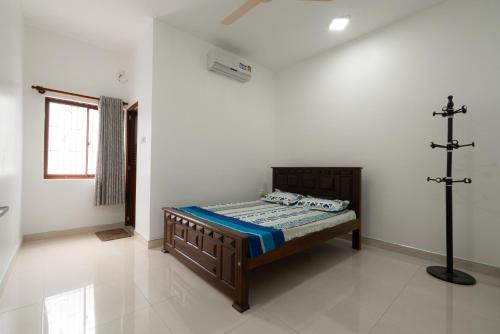 a bedroom with a bed and a cross on the wall at Sri Construction Circuit Bungalow in Batticaloa