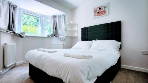 a bedroom with a large bed with a green headboard at 1 Bedroom Annex - Close to Frimley Hospital - Private Entrance in Frimley