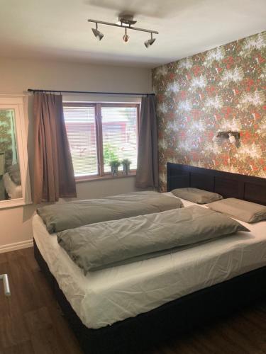 a bedroom with a large bed with a painting on the wall at Härlig Heden Vakantie Appartement in Råda