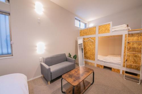 a bedroom with a couch and a bed and a table at KIZUNA HOTEL Gojo Kiyomizu-dera Kamogawa in Kyoto