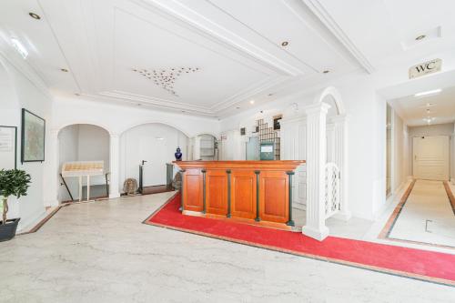 Großes Zimmer mit einem roten Teppich und einem Podium aus Holz in der Unterkunft Self-Check-In Hotel Adlon in Wien