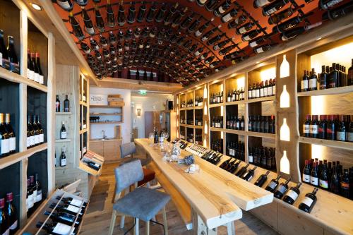 una sala di degustazione di vini con un lungo tavolo e scaffali di bottiglie di vino di Natur- und Wellnesshotel Höflehner a Haus im Ennstal
