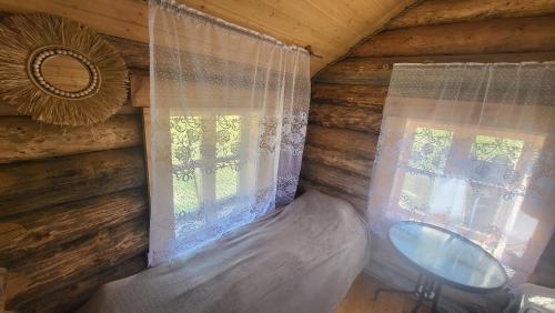 a bedroom in a log cabin with a window at Uhtjärve Ürgoru Nõiariik in Antsla