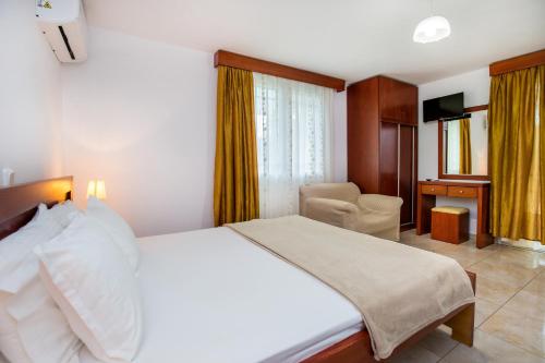 Kiriakos Holiday Home في أستريس: غرفة نوم بسرير ومكتب وكرسي