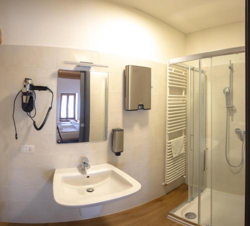 a bathroom with a sink and a shower and a mirror at Borgo Case Marian in Cison di Valmarino