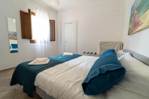 een slaapkamer met een bed met blauwe kussens erop bij Le Casette di Didi in Trapani