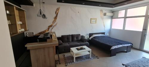 a room with a bed and a couch and a table at APARTMAN ART in Zvezdara