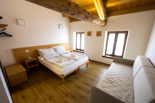 1 dormitorio con 1 cama y 1 sofá en Borgo Case Marian, en Cison di Valmarino