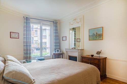 a bedroom with a large bed and a window at Paris Eiffel Tower Center residence in Paris