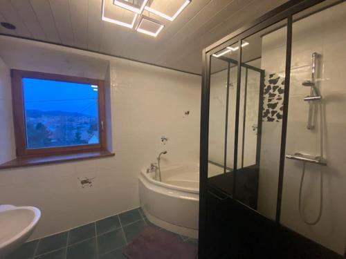 ein Bad mit einer Badewanne, einem Waschbecken und einer Dusche in der Unterkunft Logement dans maison + extérieur in Orchamps-Vennes