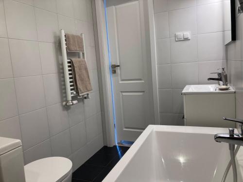 a white bathroom with a sink and a toilet at Apartament Zachody nad Wrocławiem in Wrocław