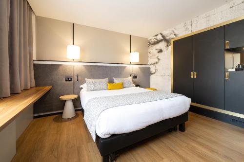 Cette chambre comprend un grand lit avec des oreillers jaunes. dans l'établissement Hôtel Le Roosevelt Lyon, à Lyon