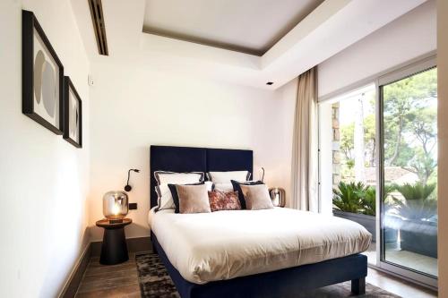 une chambre avec un grand lit et une fenêtre dans l'établissement A11 - Villa Cap Antibes Sea View 5 BDR - AC, Rooftop Pool & Parking, à Antibes