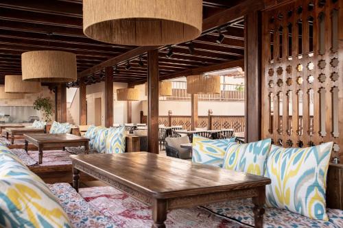 a restaurant with couches and a table and chairs at Kosh Havuz boutique hotel in Samarkand