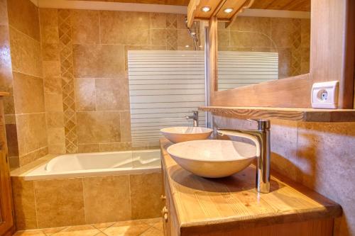 a bathroom with two sinks and a bath tub at Chalet Le Wapiti, aux pieds des pistes, à 200m du village in Notre-Dame-de-Bellecombe
