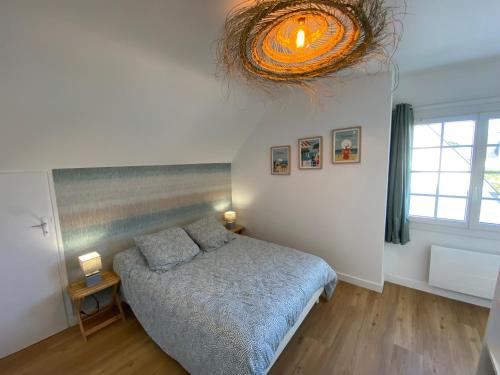 une chambre avec un lit et un lustre dans l'établissement Quiberon, à Quiberon