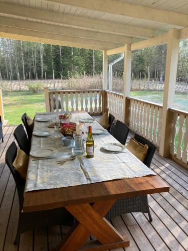 einem Holztisch auf einer Terrasse mit einem Tisch in der Unterkunft Härlig Heden Vakantiehuis in Råda