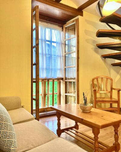 a living room with a table and a window at Ahío San Martín, Apartamentos Rurales Casa de la Villa in San Martín de Oscos