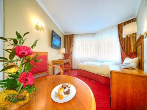 a hotel room with a table with a plate of food on it at Trip Inn Hotel Der Adelshof in Schwäbisch Hall