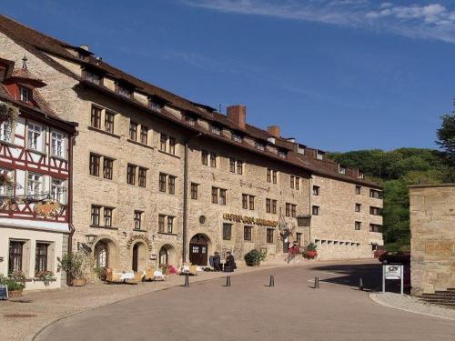 a large stone building with people sitting outside of it at Trip Inn Hotel Der Adelshof in Schwäbisch Hall
