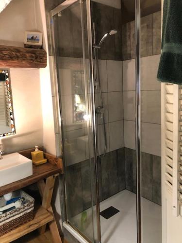 La salle de bains est pourvue d'une douche avec une porte en verre. dans l'établissement Maison basse, à Vars
