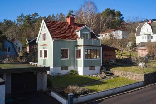 uma casa com uma casa verde e branca em 30-tals villa med närhet till centrala GBG em Gotemburgo