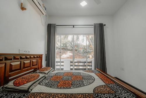 a bedroom with two beds and a window at Sri Construction Circuit Bungalow in Batticaloa