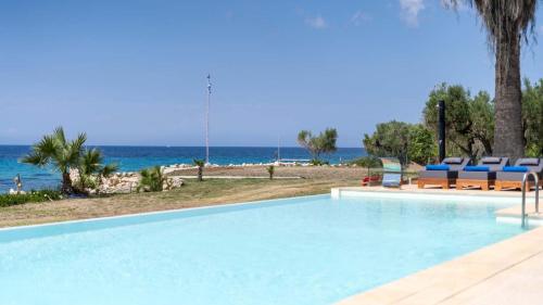 a swimming pool with a view of the beach at Pamina Mare in Nea Skioni