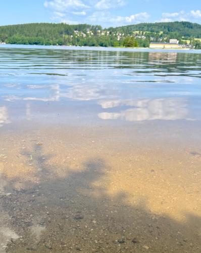 a body of water with clouds in the water at Lipno Villa Beach - Lipno Stausee - Lakeside in Loučovice