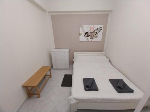 a small room with two beds and a wooden table at Goldfish Elegant Apartments in Orfánion