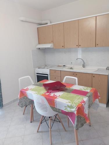 a kitchen with a table and chairs with a table and a stove at Goldfish Elegant Apartments in Orfánion