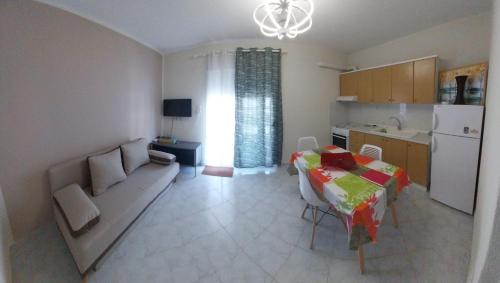 a living room with a couch and a table and a kitchen at Goldfish Elegant Apartments in Orfánion