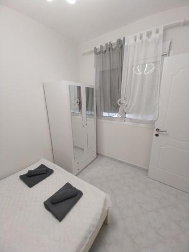 a white room with a bed and a window at Goldfish Elegant Apartments in Orfánion