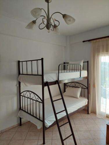 two bunk beds in a room with a ceiling fan at KARAOYLI apartments studios in Kokkino Nero