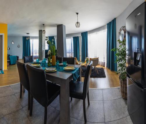 a dining room and living room with a table and chairs at GM Apart in Varna City