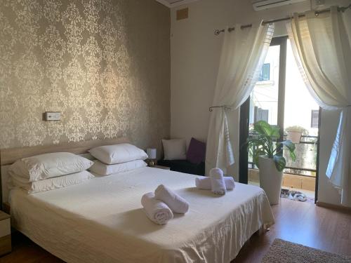 een slaapkamer met een wit bed en handdoeken bij Caris Gem in Birżebbuġa