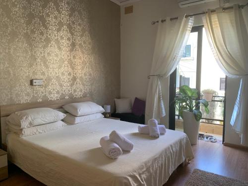 a bedroom with a white bed with towels on it at Caris Gem in Birżebbuġa
