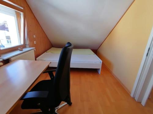 Zimmer mit einem Schreibtisch, einem Bett und einem Stuhl in der Unterkunft Wohnung für 2 Personen in Villingen-Schwenningen