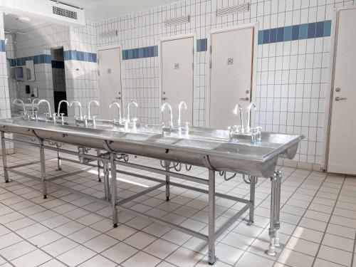 a row of sinks in a bathroom with stalls at Krongården Vandrarhem in Kristinehamn